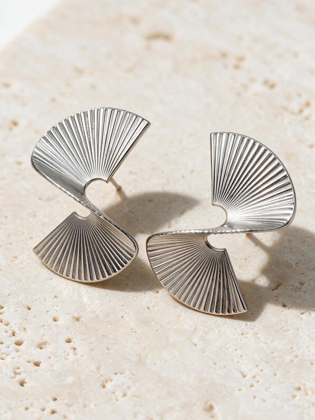 Aretes con textura plisada, color plateado, vista frontal