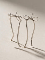 Aretes de línea sencilla, color plateado, vista frontal