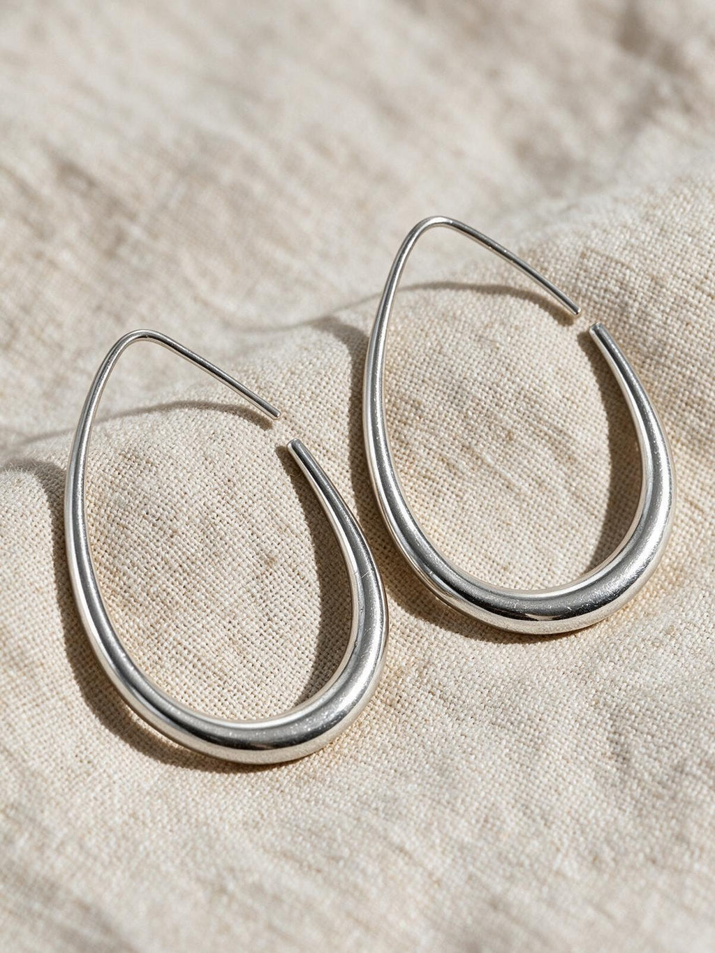 Aretes ovalados, color plateado, vista frontal