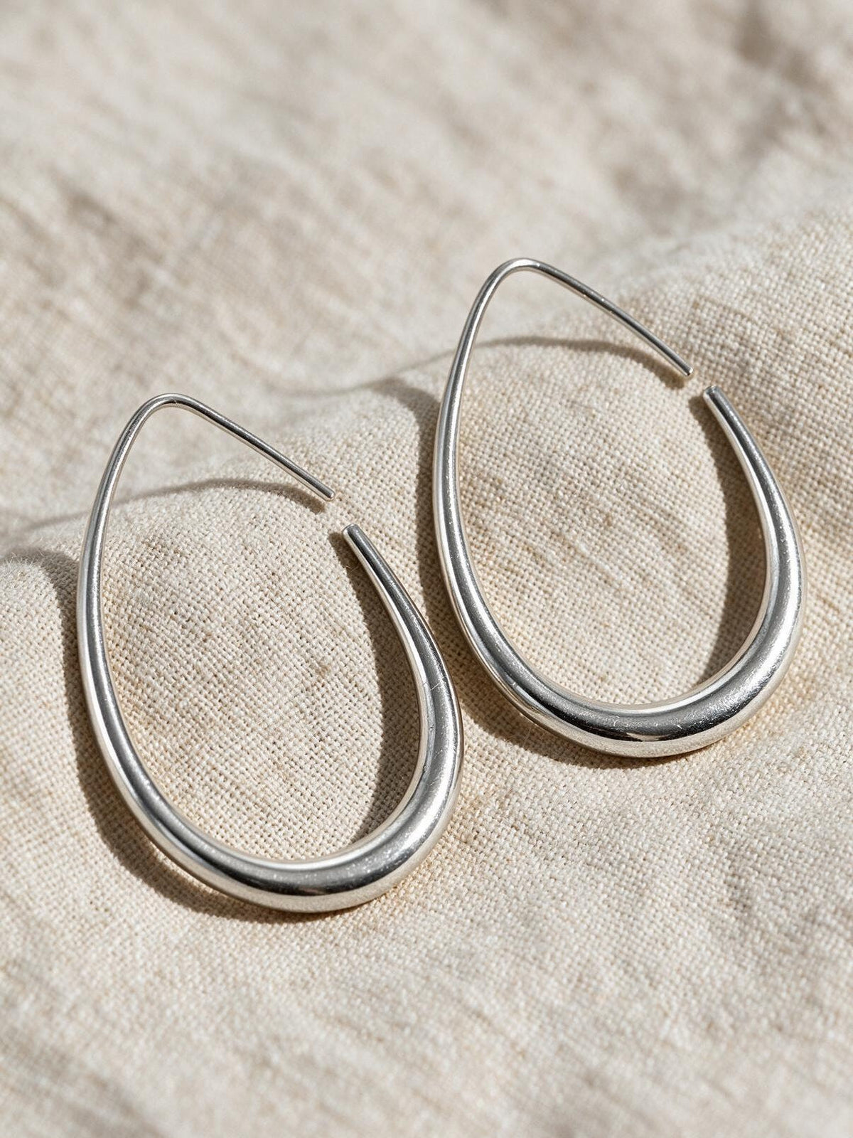 Aretes ovalados, color plateado, vista frontal