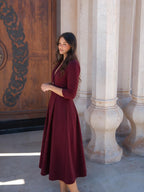 Vestido midi acampanado con cintura marcada, color vino, vista lateral